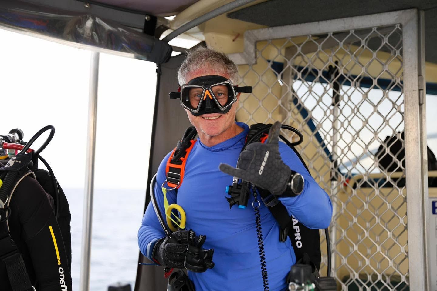 Diver in a blue wetsuit and mask on board the vessel