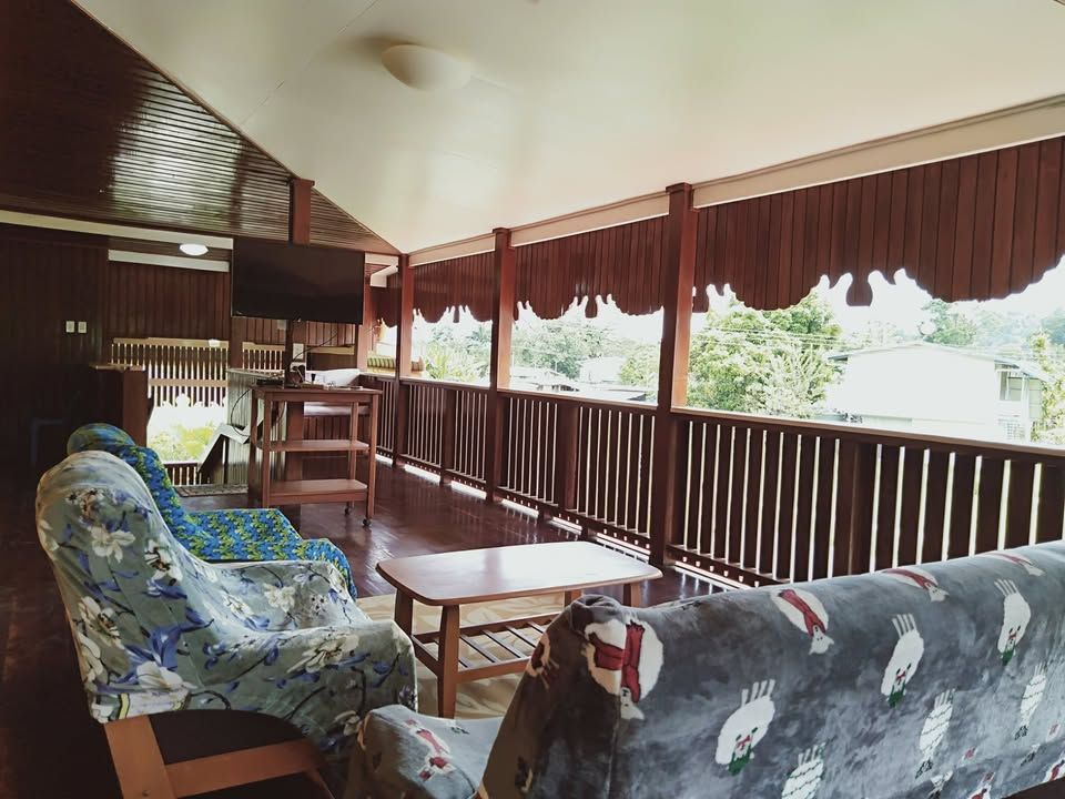 Spacious covered balcony with a lounge area and television.