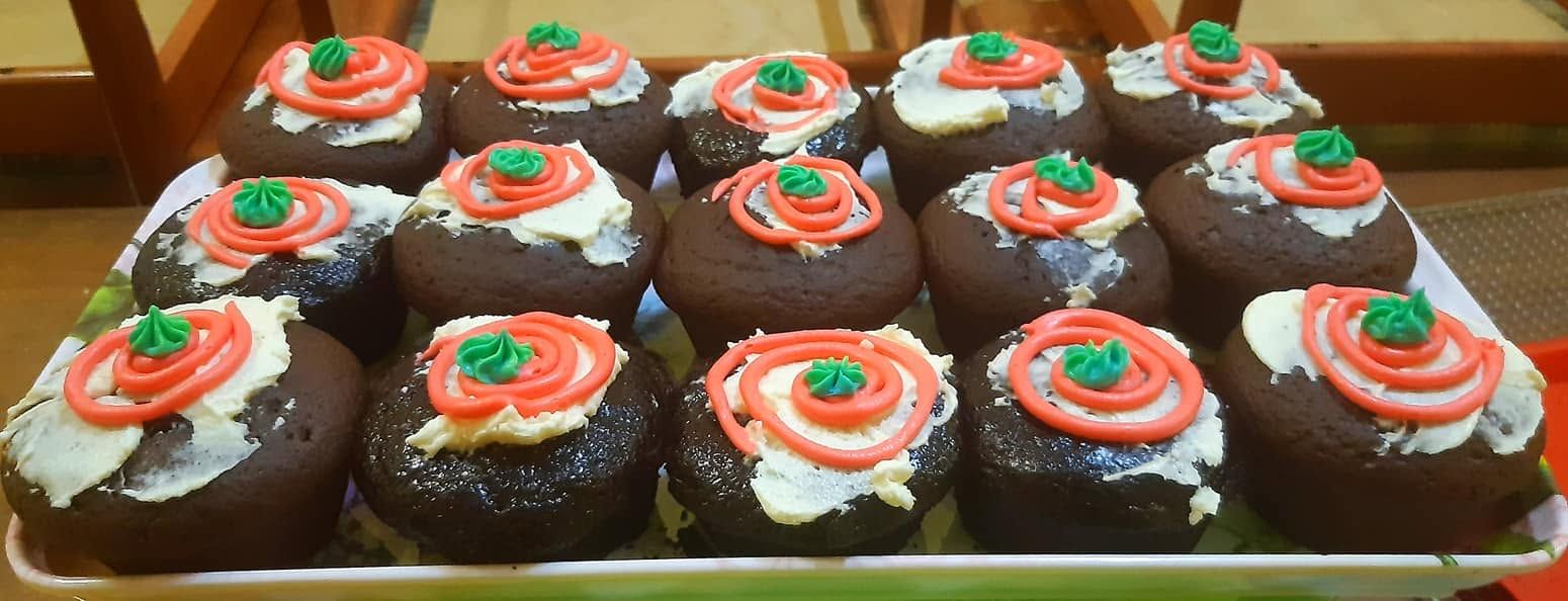 Tray of chocolate cupcakes with decorative icing.