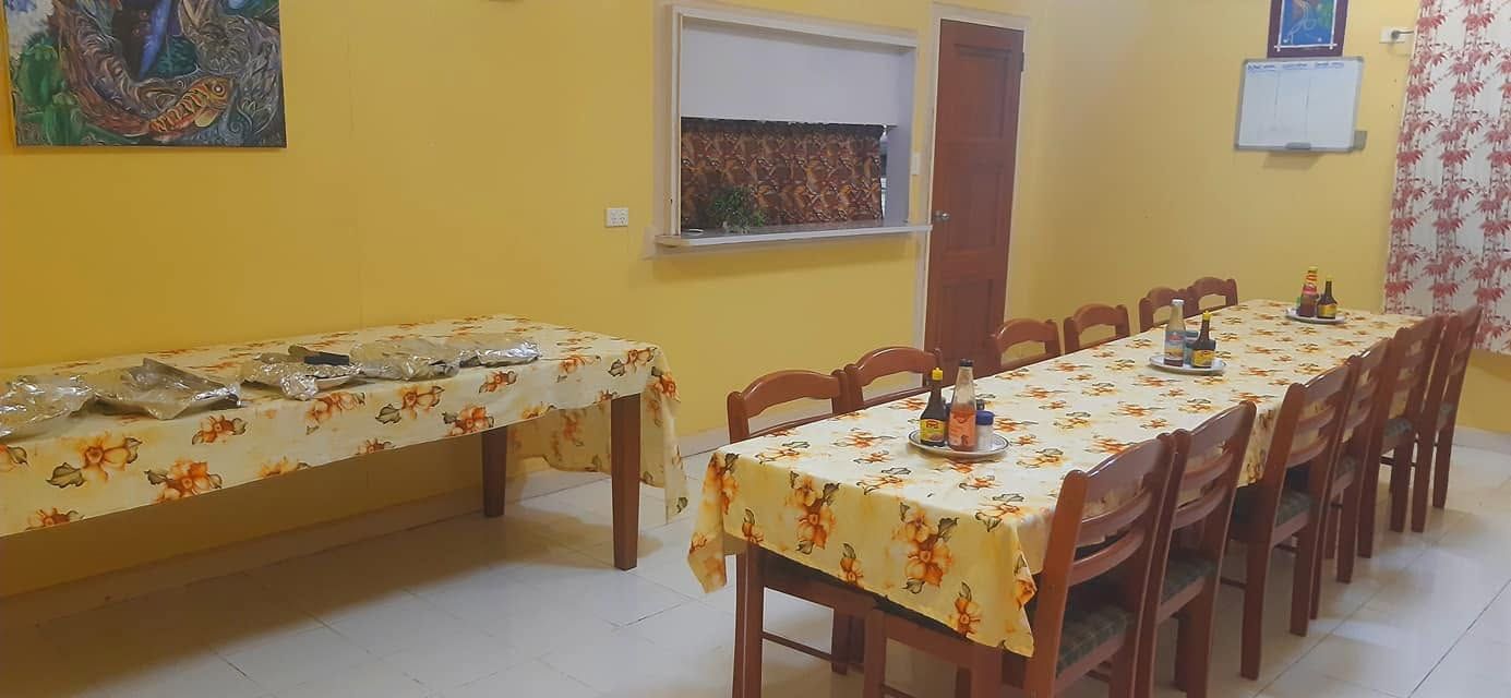 Indoor dining hall with long tables and buffet setup.
