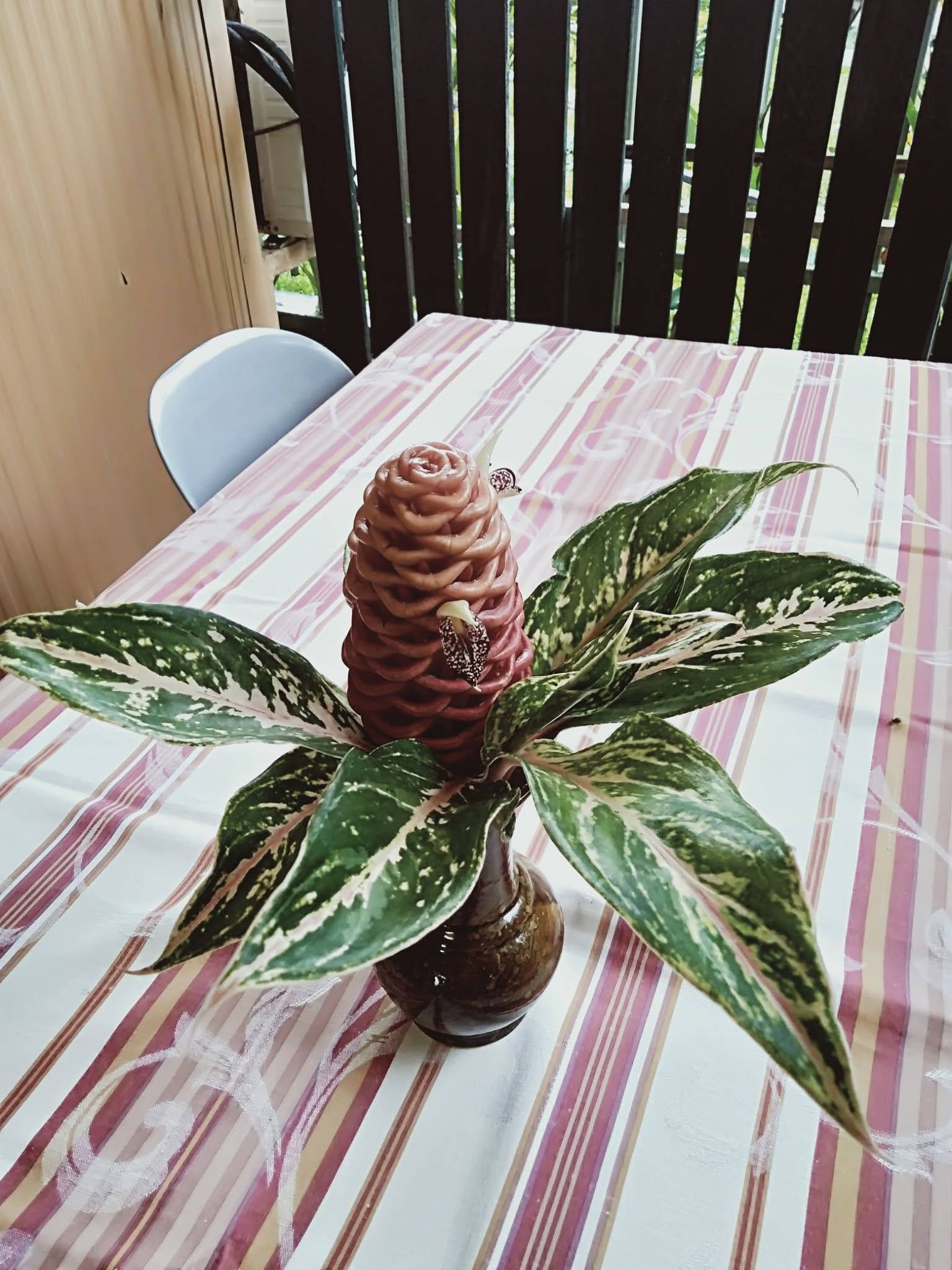 Floral centerpieces on a striped dining tablecloth.