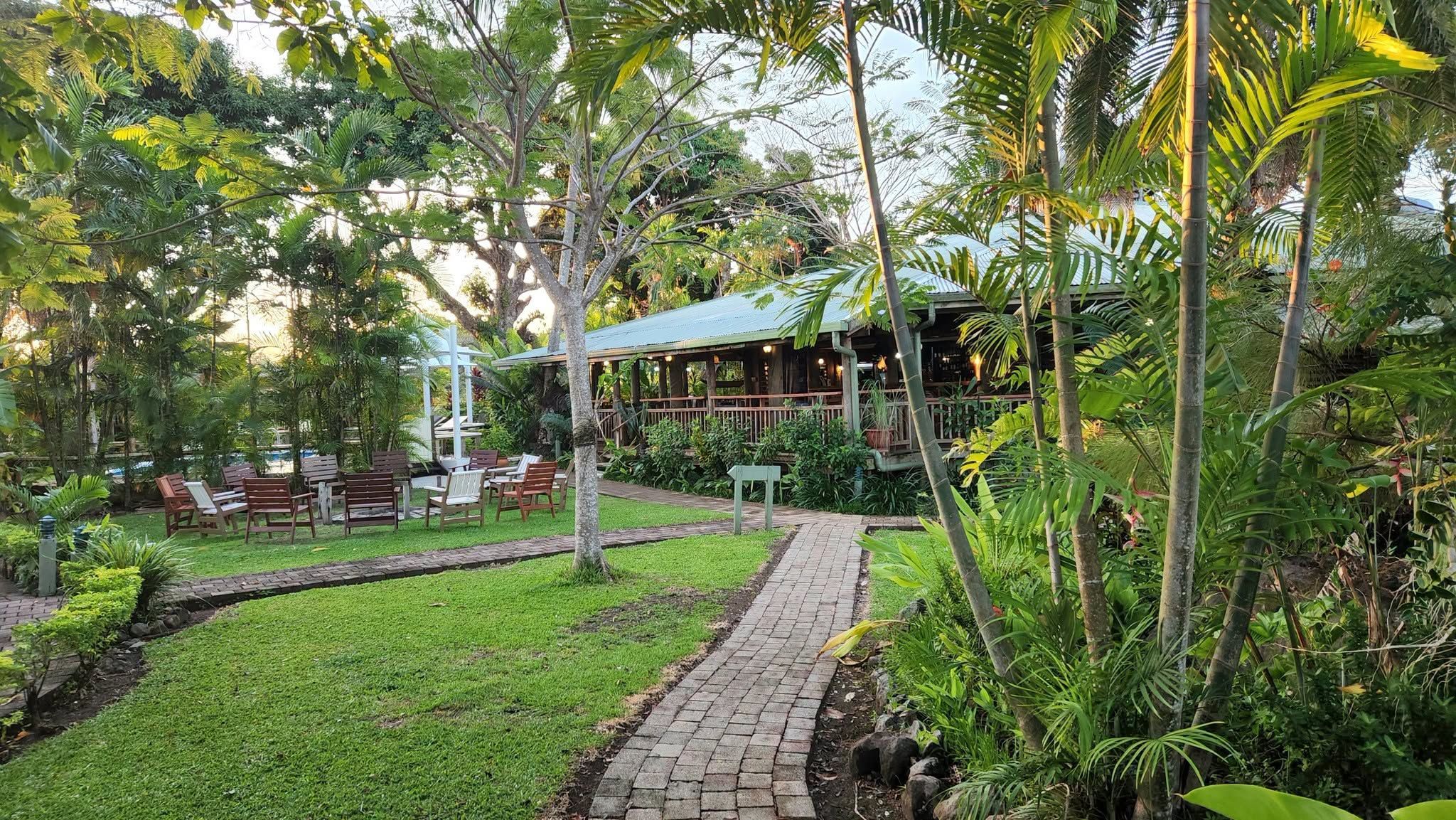 Landscaped gardens with a brick pathway leading to the resort lodge.